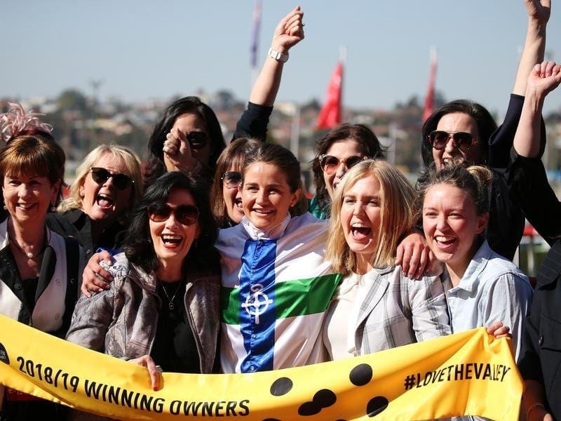 Jockey Michelle Payne has celebrated city success as a trainer with a large group of owners. Trainer-jockey Michelle Payne and her winning owners.